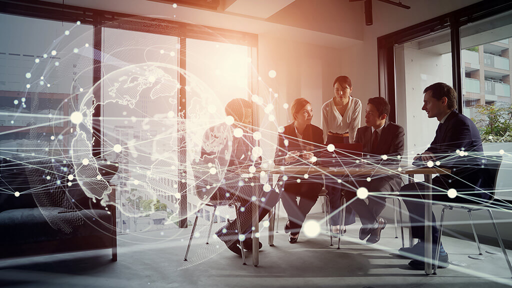 Reunião em sala de vidro com 5 profissionais alinhando estratégias, com ilustrações de conexões tecnológicas sobrepostas, simbolizando inovação, integração de dados e colaboração empresarial.