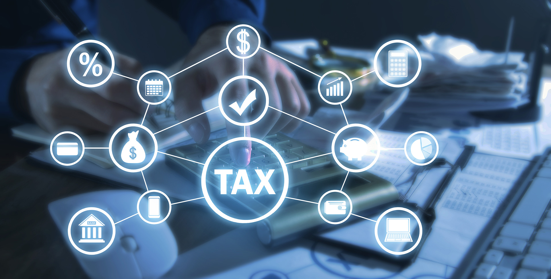 Gestão tributária digital - ícone central de “TAX” conectado a símbolos de finanças, impostos, calculadora e análise de dados sobre mesa de trabalho.
